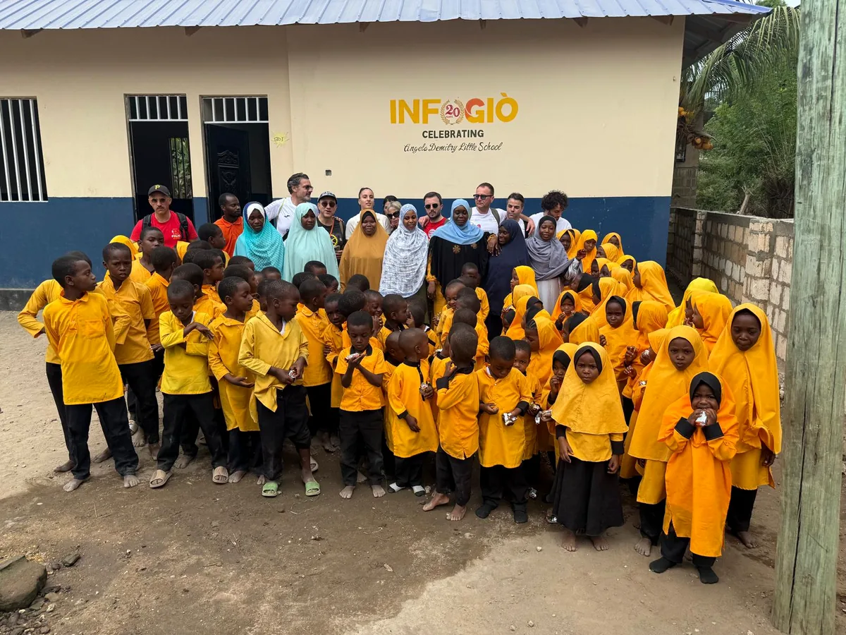 Gruppo di bambini e volontari davanti alla scuola a Zanzibar